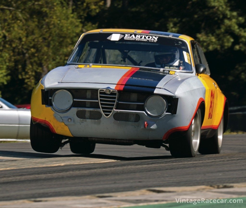 Rob Mocas hops a wheel over the curbs at the Oak Tree turn in his 1967 Alfa Romeo GTV.Photo: Fred Lewis 