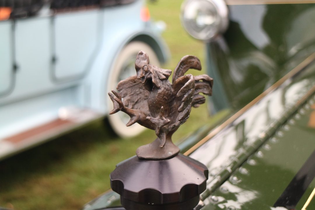 This mascot appears to be saying "just don't mess with this 1914 Cadillac!"