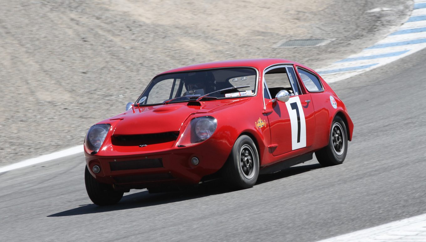 Three-quarter front view of a red 1967 Mini Marcos GT on a racetrack