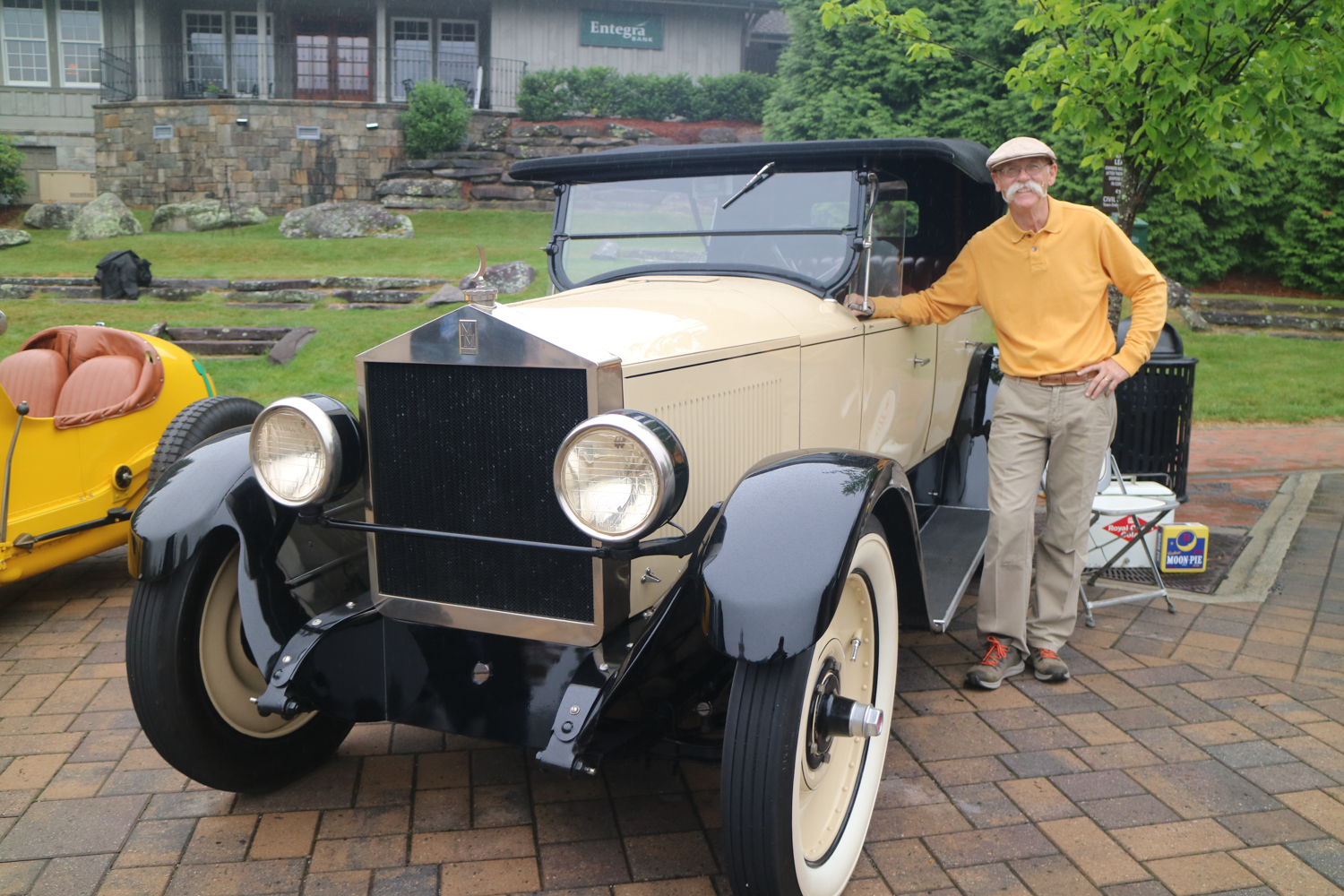 Dennis Gage beside a Moon automobile owned by a descendent of the man who built this car.