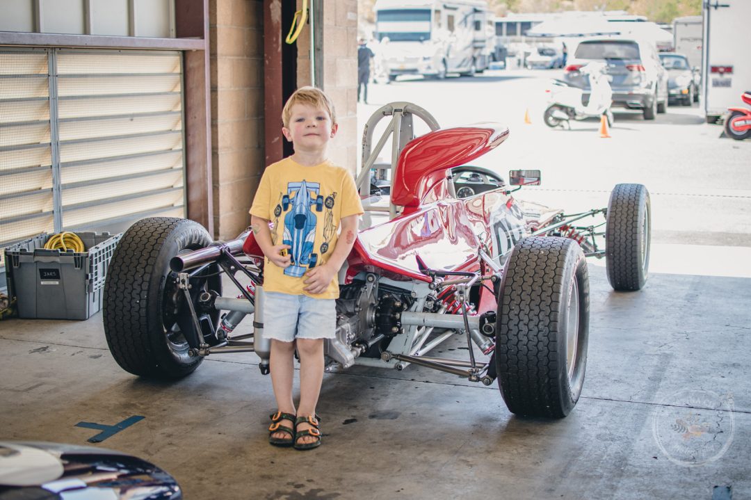 A young racing enthusiast asked to have his picture taken next to this racecar Kristina Cilia