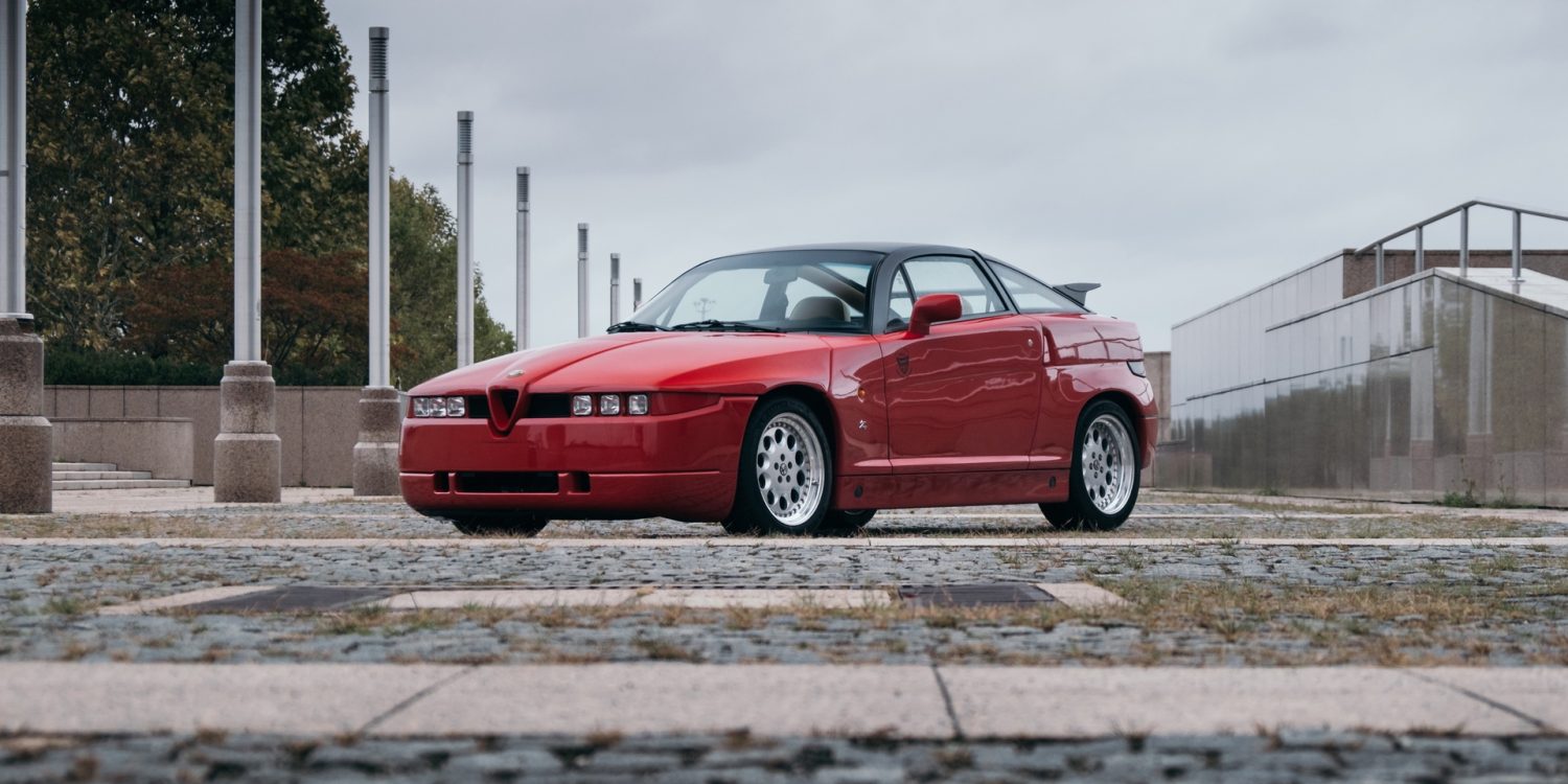 Red Alfa Romeo SZ on cobblestones in city