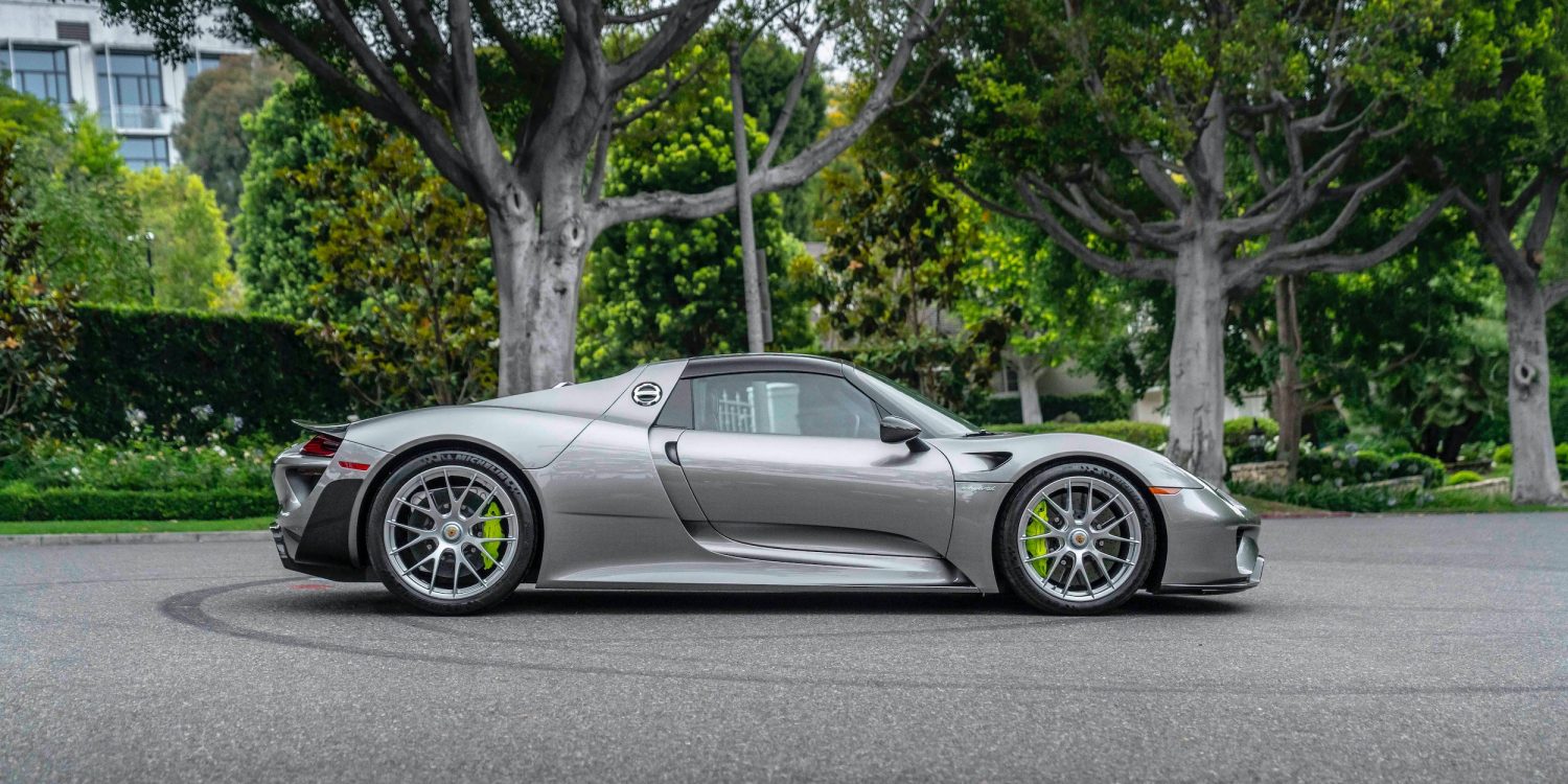 Silver 2015 Porsche 918 Spyder Weissach Edition on road with trees in background