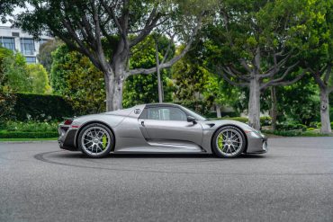 Silver 2015 Porsche 918 Spyder Weissach Edition on road with trees in background