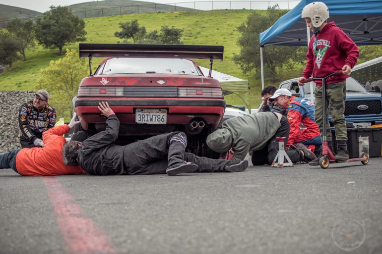 Team Magnum Pies inspects their 1984 Mazda Rx7 after it got towed off the track