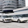 Two BMW cars parked outside building