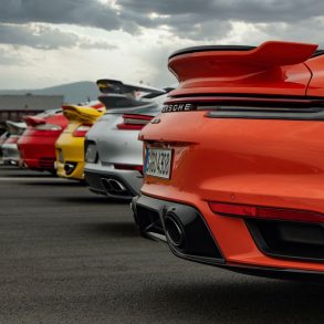 Row of Porsche cars in multiple colors on road