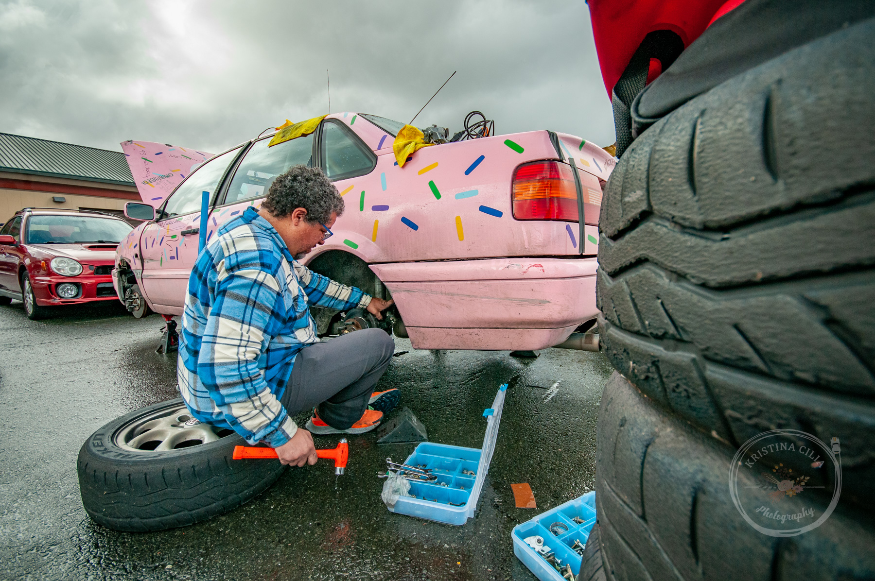 A member of the Big Pink team works on the brakes of their 1997 VW Passat Kristina Cilia