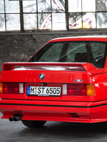 Red BMW M3 E30 inside a garage