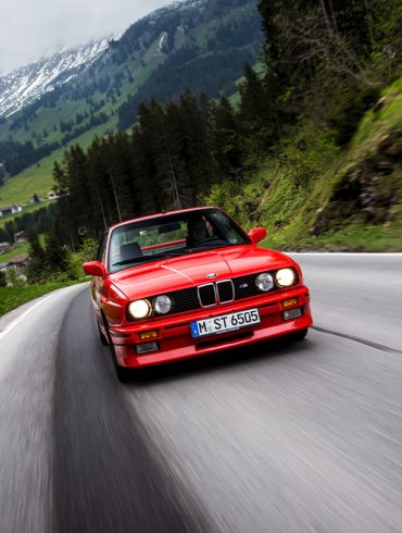Red BMW M3 E30 on curvy road