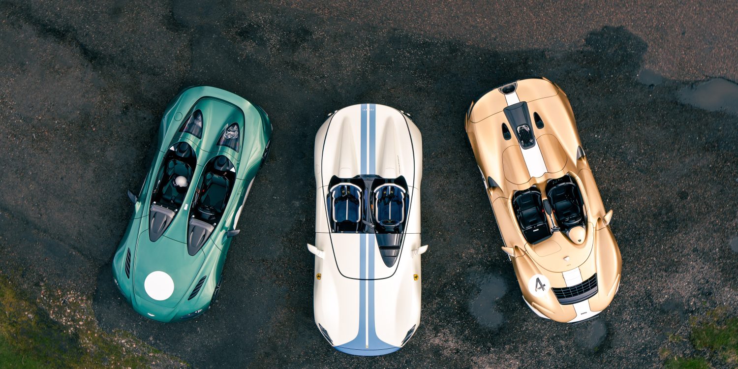 Aerial image showing a green Aston Martin V12 Speedster, white and blue Ferrari Monza SP2 and gold and white McLaren Elva.