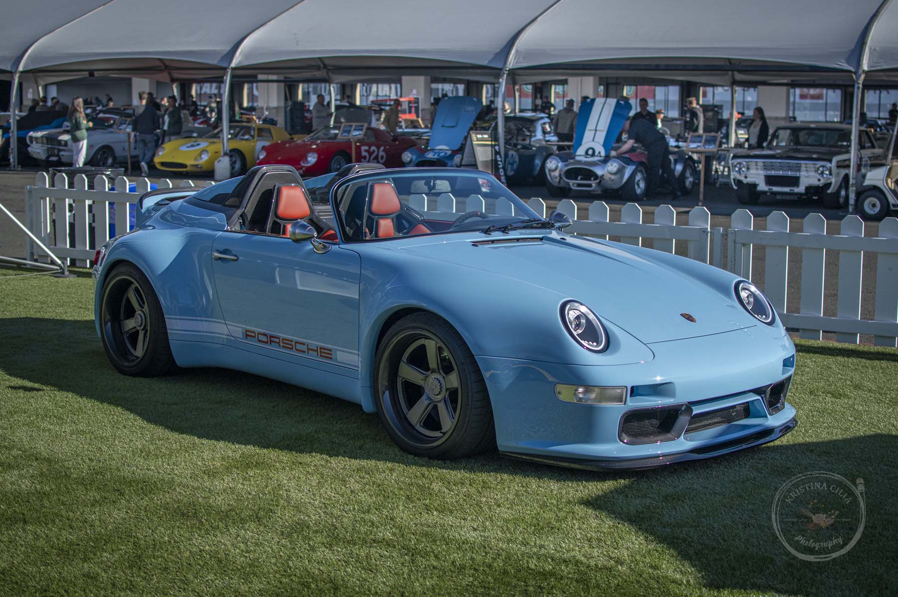 This Porsche 911 Speedster by Gunther Werks is a stark contrast to the older racercars lined up behind it in the paddock