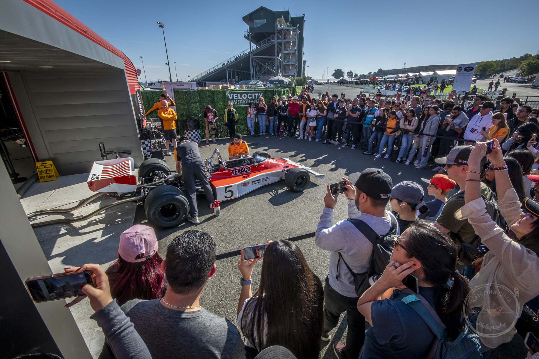 An enthusiastic crowd of McLaren fans gather around the F1 M23 to listen as its warmed up. Emerson Fittipaldi won the Belgian BP with this car in 1974.
