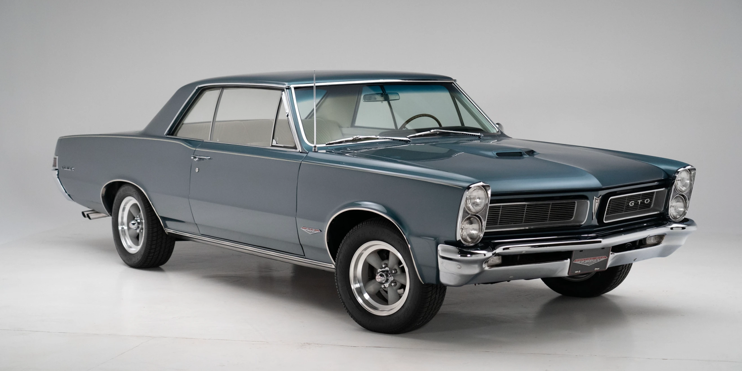 Three-quarter side view of a restored 1965 turquoise Pontiac GTO coupe