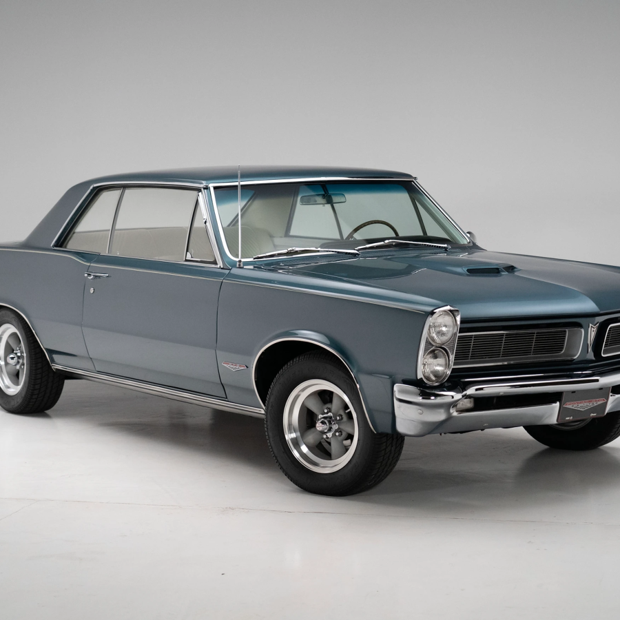 Three-quarter side view of a restored 1965 turquoise Pontiac GTO coupe