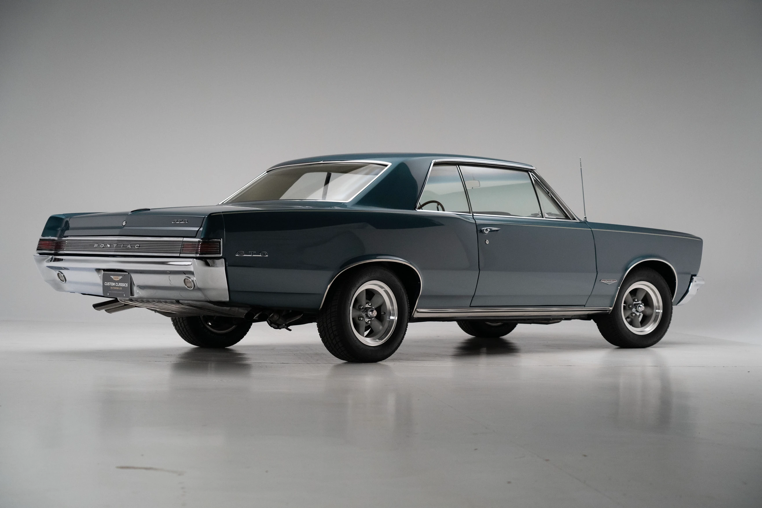  Three-quarter side view of a restored 1965 turquoise Pontic GTO