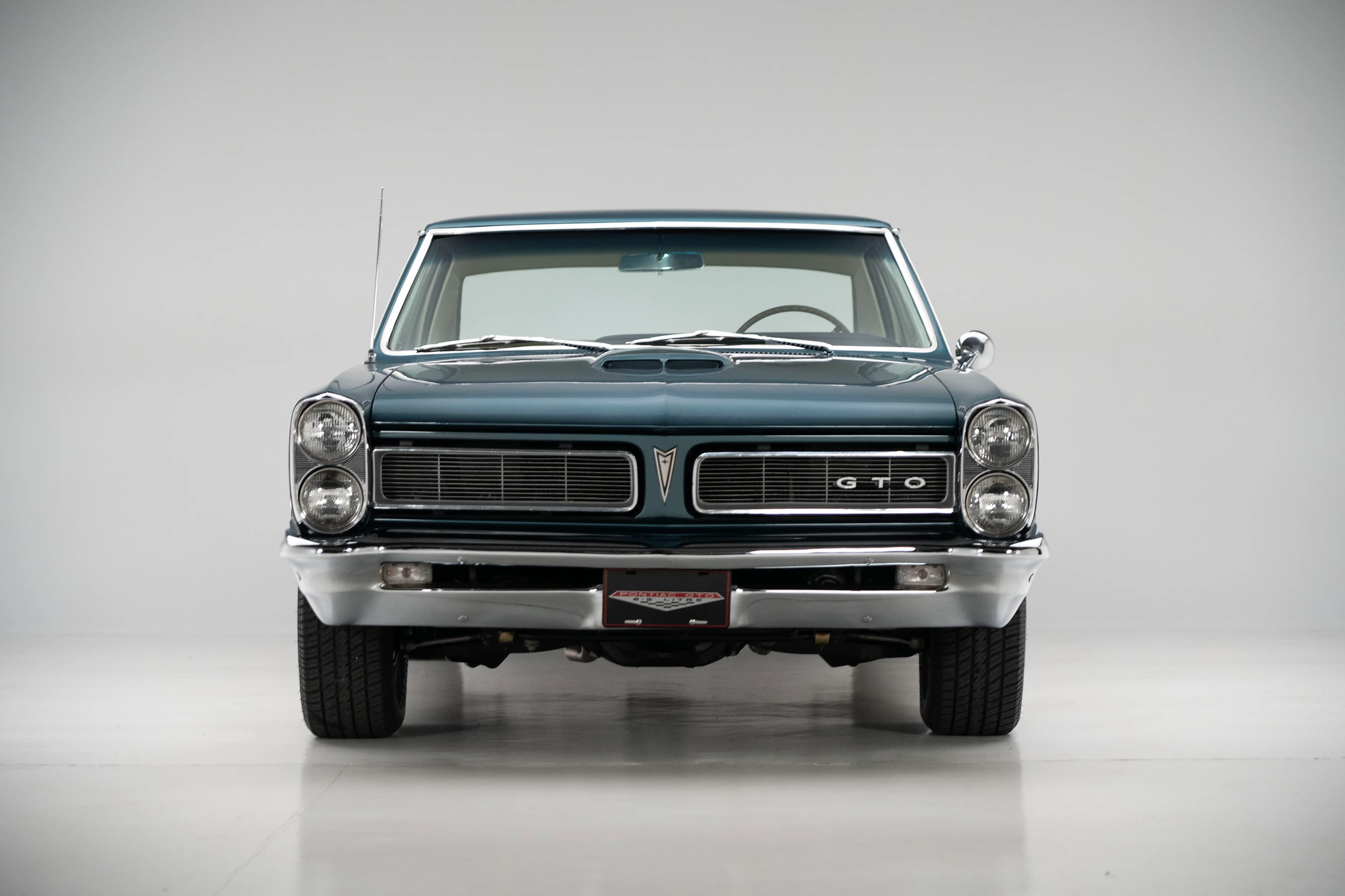 Front view of a restored 1965 Turquoise Pontiac GTO Coupe