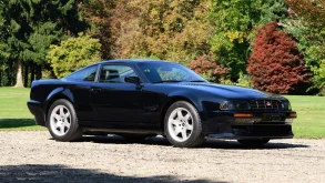 Three-quarter side view of a 1995 black Aston Martin Vantage V550