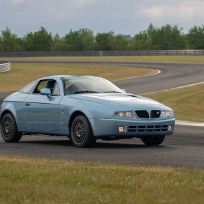 Three-quarter front view of a blue Lancia Hyena by Zagato at a racetrack