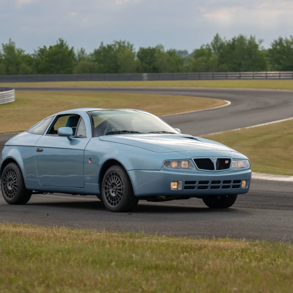 Three-quarter front view of a blue Lancia Hyena by Zagato at a racetrack