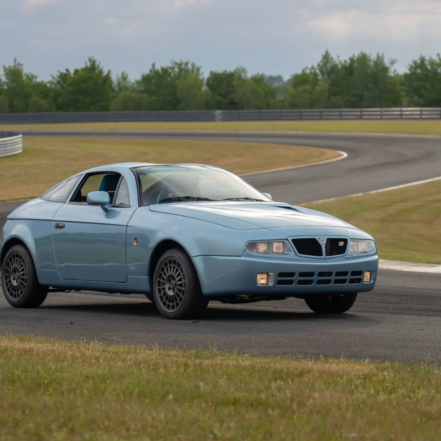 Three-quarter front view of a blue Lancia Hyena by Zagato at a racetrack