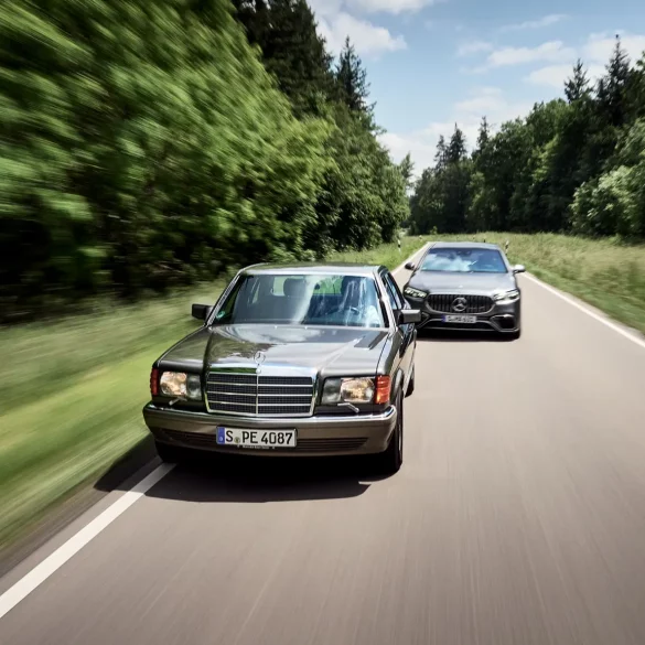 Classic Mercedes-Benz S-Class driving alongside a modern Mercedes-AMG S-Class on a forest road.