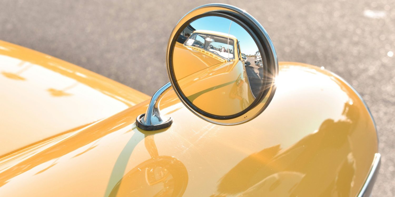 Rearview mirror on a yellow classic car