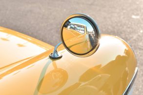 Rearview mirror on a yellow classic car