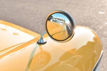 Rearview mirror on a yellow classic car