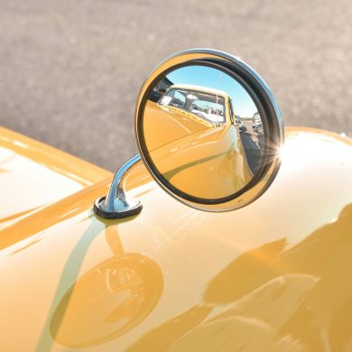 Rearview mirror on a yellow classic car